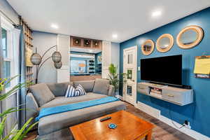Living area with wood finished floors, plenty of natural light, and recessed lighting