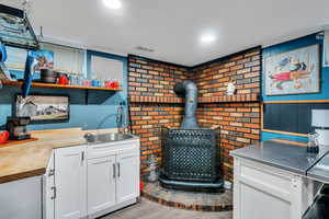 Detailed view of a wood stove, wood finished floors, and recessed lighting