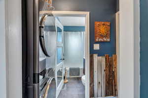 Full bath featuring toilet and dark tile patterned floors