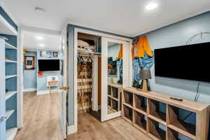 Walk in closet with light wood-style floors