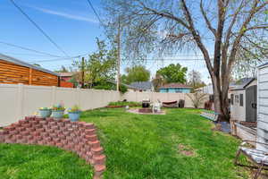 Fenced backyard featuring a fire pit and a patio area