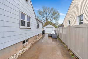 View of patio / terrace with driveway, an outdoor structure, and a garage