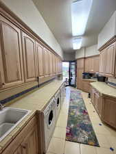 Laundry area featuring a textured ceiling and washing machine and clothes dryer