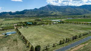 Aerial view of sparsely populated area featuring extensive farmland and a water and mountain view