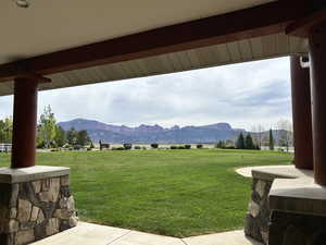 View of grassy yard with a mountain view and a patio