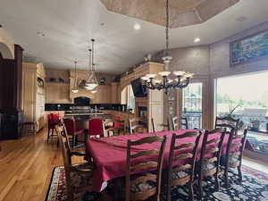 Dining space featuring light wood-style flooring, hanging lights, and arched walkways
