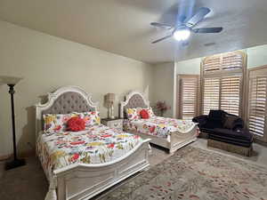 Carpeted bedroom featuring ceiling fan