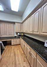 Kitchen featuring dark stone countertops, light wood-type flooring, and light wood finish cabinetry
