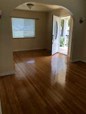 Foyer featuring arched walkways and light wood-type flooring
