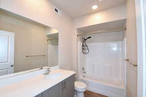 Full bath with vanity, bathtub / shower combination, recessed lighting, and dark wood finished floors