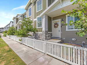 View of exterior entry featuring board and batten siding, a gate, a residential view, and stone siding