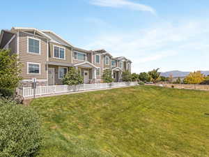 Craftsman-style home with a front yard, board and batten siding, stone siding, and a mountain view