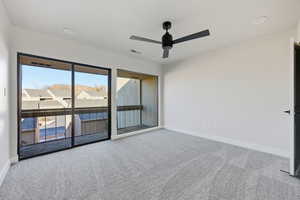Unfurnished room with light colored carpet, a ceiling fan, and a residential view