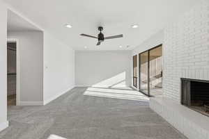Unfurnished living room featuring carpet flooring, a fireplace, recessed lighting, and ceiling fan