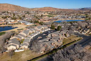 Aerial view of property and surrounding area with a water and mountain view and nearby suburban area
