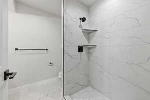 Full bath featuring toilet and tiled shower