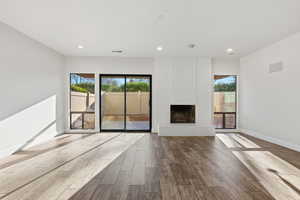 Unfurnished living room with wood tiled floors, a fireplace, and recessed lighting