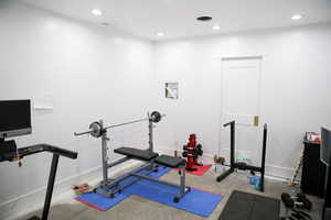 Workout area with concrete floors. The pocket door leads to an unfinished bathroom