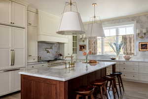 High end appliances, hardwood floors,  bar area, and a center island with sink