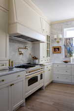 Kitchen featuring Italian gas range with two ovens, hardwood wood flooring, and marble countertops