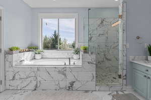 Bathroom with a marble finish shower, light marble finish flooring, and a bath