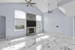 Unfurnished living room featuring a ceiling fan, a large fireplace, and vaulted ceiling