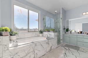 Primary Bathroom featuring a marble finish shower, vanity, a garden tub, light marble finish flooring, and recessed lighting