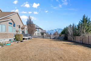 Fenced backyard featuring a deck with mountain view