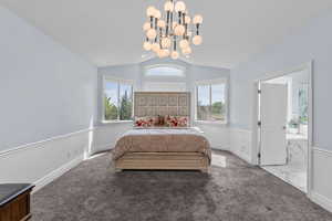 Bedroom featuring carpet floors, vaulted ceiling, and a chandelier