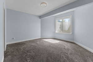 Carpeted spare room featuring baseboards