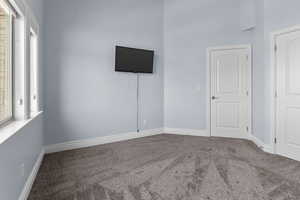 Unfurnished bedroom featuring carpet and baseboards