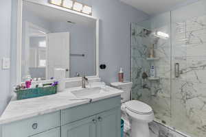 Bathroom featuring vanity, a marble finish shower, and marble finish floors