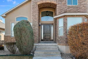 Entrance to property with stone siding and stucco siding