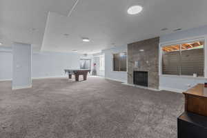 Unfurnished living room with carpet, a high end fireplace, and billiards table