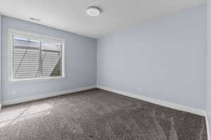 Carpeted empty room with baseboards