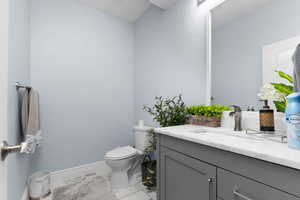 Bathroom featuring vanity and light marble finish floors