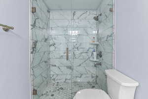 Bathroom with toilet and a marble finish shower