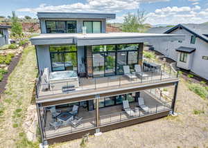 Back of property with an outdoor living / dining area, a deck, and stucco siding