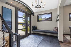 Foyer featuring wood finished floors and suspended lighting