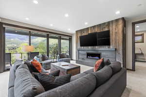 Living area featuring light colored carpet, a fireplace, plenty of natural light, and recessed lighting