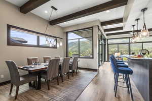 Dining space featuring dark wood-style flooring, beam ceiling, a mountain view, and recessed lighting
