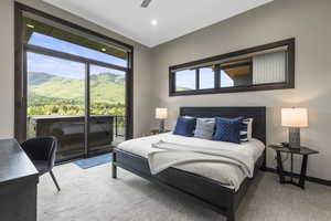 Carpeted bedroom featuring access to exterior, a ceiling fan, and a mountain view