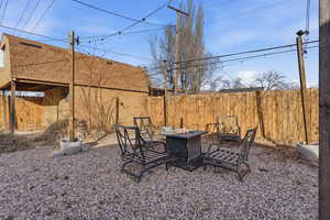 Fenced backyard with a fire pit and pea gravel