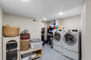 Spacious Laundry room with electric dryer hook up and epoxy flooring, and recessed lighting