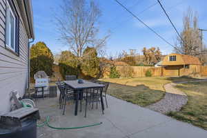 Fenced backyard with outdoor dining area, and patio