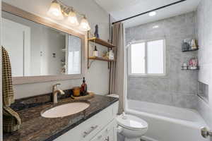 Bathroom with shower / bath combo with shower curtain and vanity