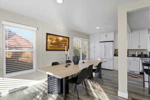 Dining area with dark wood-style floors and recessed lighting