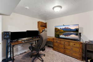4th bedroom featuring light carpet and a textured ceiling