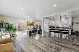 Living room with laminate floors, recessed lighting, and a textured ceiling