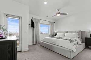 Master Bedroom with access to exterior, light carpet, and ceiling fan